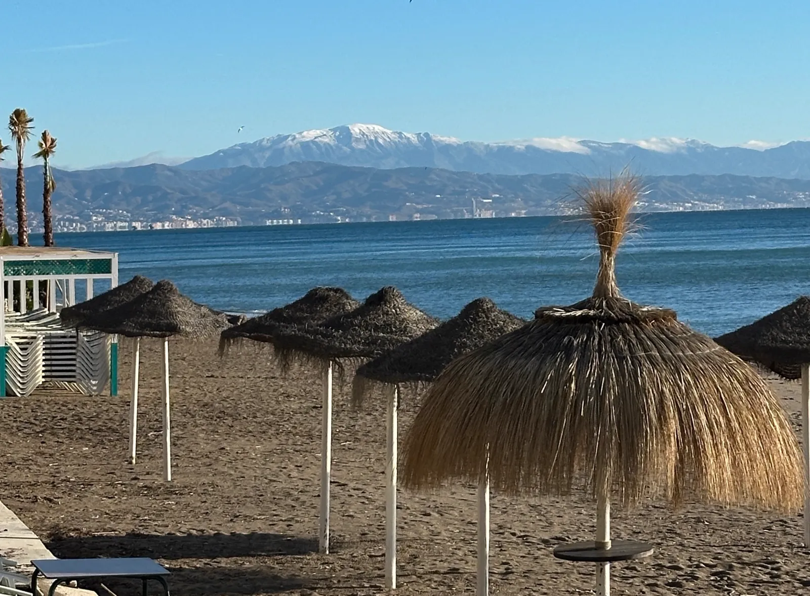 Snow-capped mountains across the bay, seen from the beach